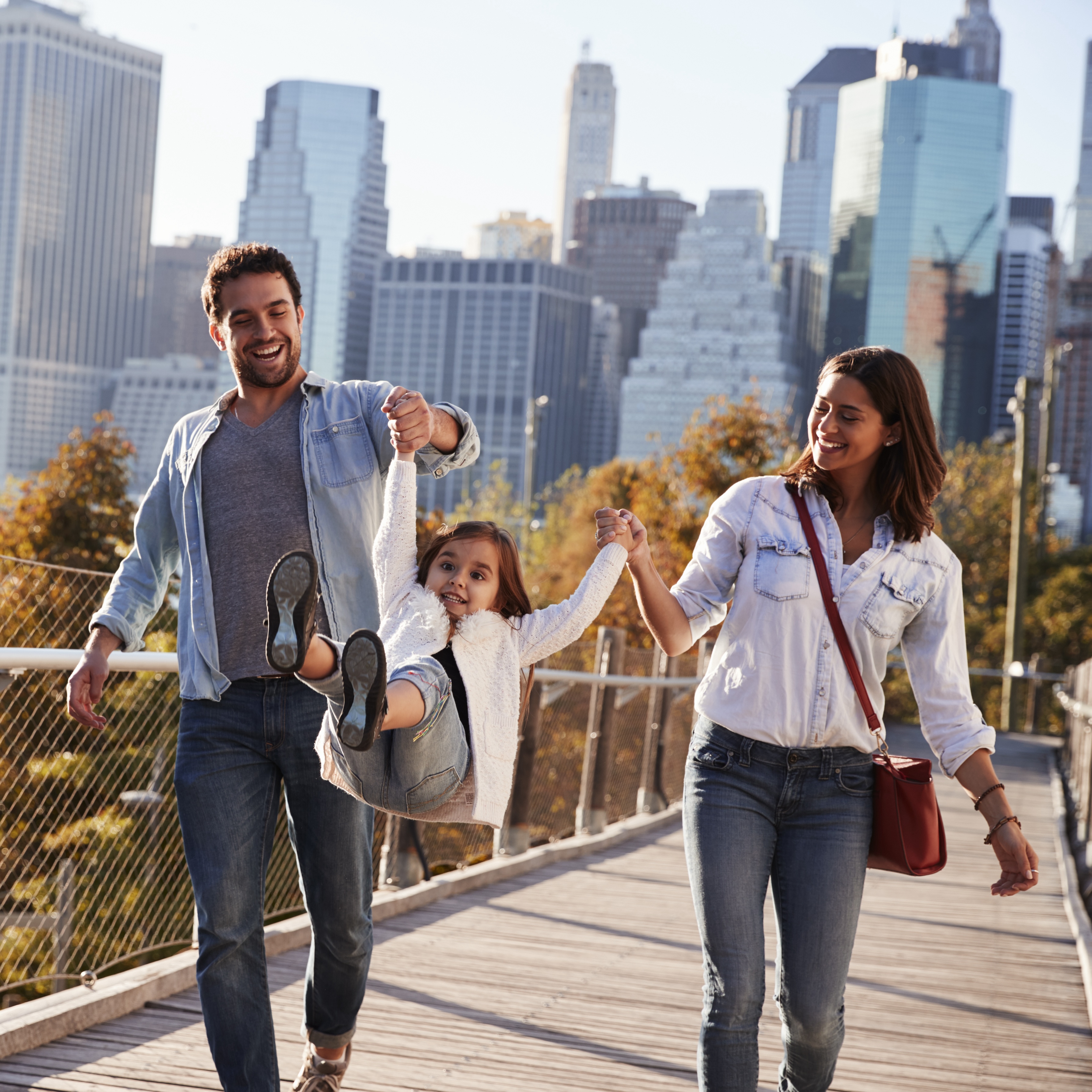 Young family with daughter taking a walk on footbridge